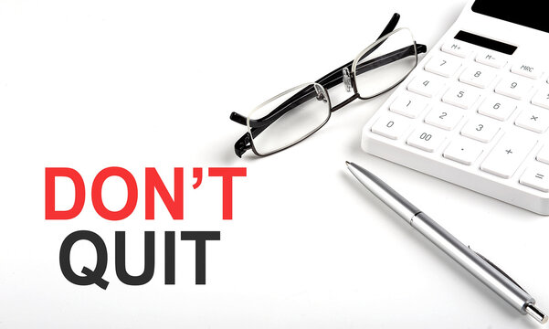 DON'T QUIT Concept. Calculator,pen and glasses on the white background