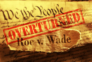 Roe V Wade newspaper headline with Overturned stamp on the United States Constitution