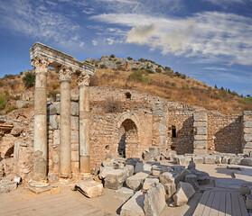 Obraz premium Ancient city ruins and pillars of Ephesus in Turkey in the day. Traveling abroad, overseas for holiday, vacation, tourism. Excavated remains of historical stone building in Turkish history, culture