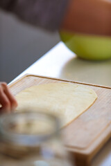 Vertical selective-focus shot of a dough on a cutting board