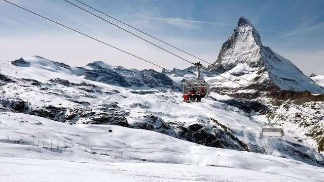 Beautiful footage of the famous Zermatt ski resort with the iconic Matterhorn peak in the alps in winter in Switzerland. People enjoying magical ski resort. 