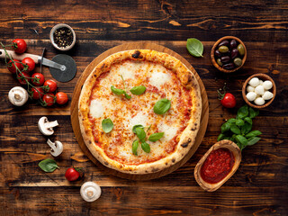 Pizza Margherita and ingredients on wooden background
