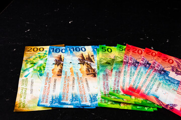 Closeup of Swiss franc banknotes on a dark surface - world money concept