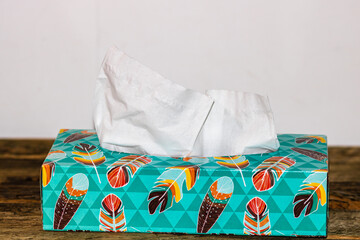Closeup of a box of white paper tissues on a wooden table
