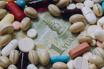 Photo of a Chinese 1 Yuan bill among pills of many shapes and colors that could probably be used to illustrate the economics of the Chinese pharmaceutical or drug industry.