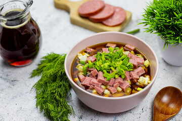 Okroshka - russian national food with meat, potato, kvass or kefir, radish and parsley on white background
