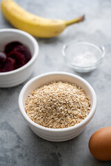 Ingredients for beetroot pancakes, banana, oats, an egg, beetroot. Cooking healthy food.