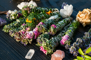 Smudge sticks and crystals on a black wooden table