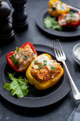 Stuffed bell peppers with whole rice and vegetables dark background. Homemade healthy food
