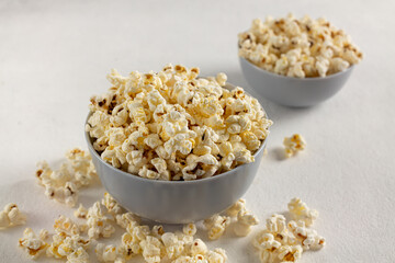 A bowl of delicious popcorn on a light background
