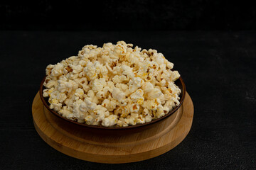 A bowl of delicious popcorn on a dark background