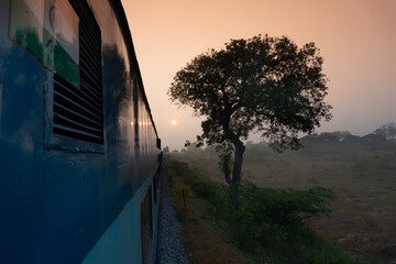 A trian running towards horizon where sun is rising, Indian railway stock Image,