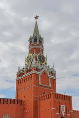 Fototapeta na wymiar The Spasskaya Tower of the Moscow Kremlin on Red Square, with huge clock and five stars on top - The five-pointed red star has often served as a symbol of communism in Russia.
