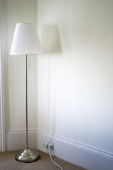 A large white lamp against a white wall. Empty room with a lonely lamp. Design.