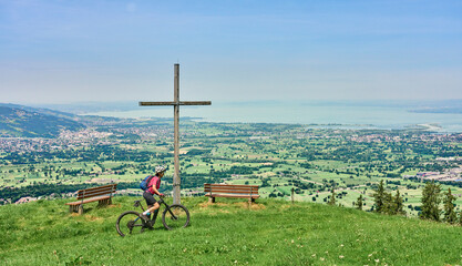 nice senior woman riding her electric mountain bike  in the Bregenzer Wald mountain range above Bregenz and Lake of Constance in Vorarlberg, Austria
 - obrazy, fototapety, plakaty