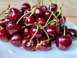 Cherries on a plate. Sweet cherry with water drops close-up. Cherry background.
