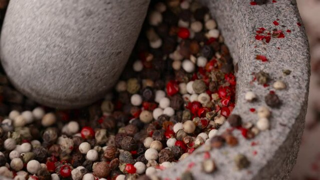 Mixed of dried peppercorns crushed and grinded in kitchen mortar and pestle