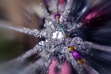 Silver crystal snowflake star decoration detail on a Christmas tree, pink glass baubles bg