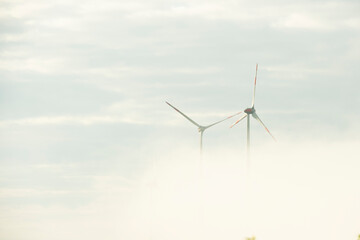 Fototapeta na wymiar Windräder die durch ein Wolkenmeer stechen. 