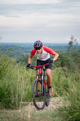 Obraz premium Mountain bikers ride MTB, mountain bike downhill to the extreme. Asian man rides MTB, mountain bike downhill in the wild to extremes. Extreme Sport and MTB, mountain bike downhill Concept.