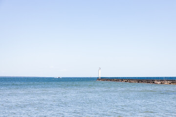 Obraz premium Lighthouse beacon at the end of a breakwater