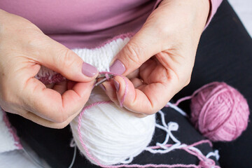 Process of knitting by elderey woman: arms, spins, thread, yarn - close up