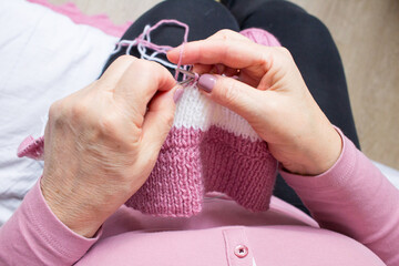 Yarn knitting process by elderey woman: arms, spins, thread - closeup