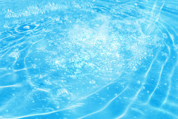 close-up of a beautiful fizzy water source, sparkling water surface with water jet in vibrant light blue color, water texture background concept for spa, cosmetics, water resource