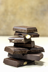 Dark chocolate almond stack, chocolate bars and block on marble background