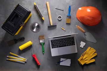 Laptop and construction work tools on floor background texture. Renovation concept