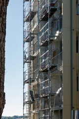 Facade of a building under renovation, covered with scaffolding