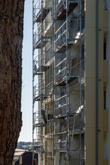 Facade of a building under renovation, covered with scaffolding