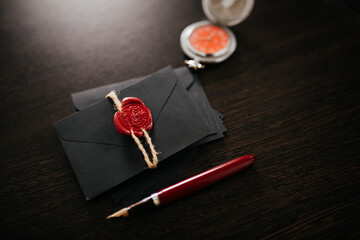 Notary tools. Black envelopes with red wax seal on a dark wooden table