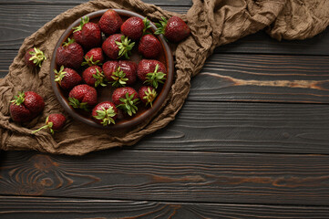 Ripe strawberries on a dark rustic background.