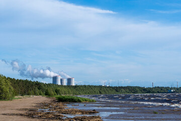 cooling towers of a nuclear power plant on the seashore against a sky