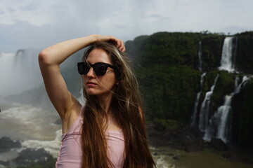 In the photo, the girl poses against the backdrop of Iguazu Falls — a complex of 275 waterfalls on the Iguazu River, located on the border of Brazil (Paraná state) and Argentina (Misiones province)