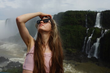 In the photo, the girl poses against the backdrop of Iguazu Falls — a complex of 275 waterfalls on the Iguazu River, located on the border of Brazil (Paraná state) and Argentina (Misiones province)