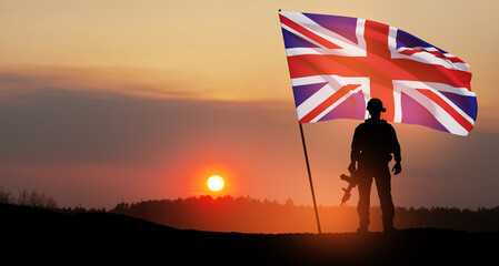 Silhouette of soldier with United Kingdom flag on background of sunset.