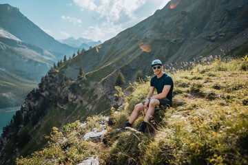 Un homme randonneur qui est en montagne lors d'une randonnée et qui regarde le magnifique...