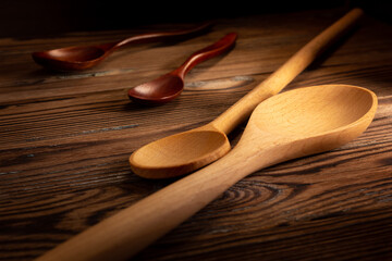 Various wooden spoons on a wooden background.