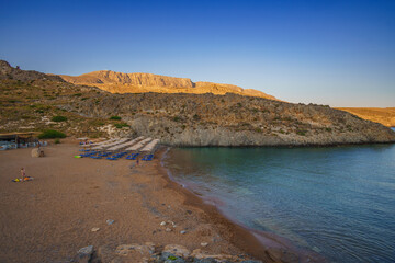 Fototapeta premium View of the famous rocky beach Melidoni in Kythira island at sunset. Amazing scenery with crystal clear water and a small rocky gulf, Mediterranean sea, Greece, Europe.