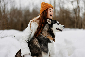woman outdoors in a field in winter walking with a dog winter holidays