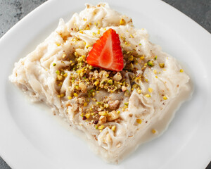 Close up of Traditional turkish meal - Gullac. Milk dessert sprinkled with ground nuts and pistachios. Ramadan dish