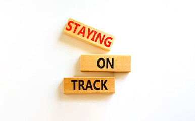 Staying on track symbol. Concept words Staying on track on wooden blocks on a beautiful white table white background. Business, motivational and staying on track concept. Copy space.