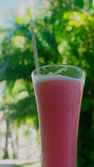 Cocktail on the background of palm trees. Refreshing ice drink on the beach, the mood of a vacation in the tropics