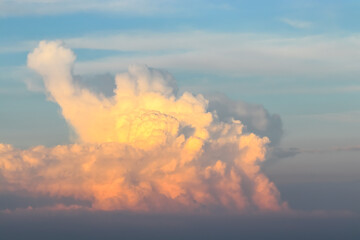 Large orange cumulonimbus cloud in the evening at sunset - obrazy, fototapety, plakaty