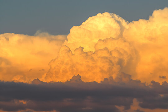 Orange cumulonimbus cloud at sunset