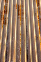 Background of rusty metal material mounted on a ceiling of a factory in panels with vertical lines.