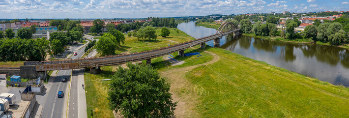 Żelazny most kolejowy nad rzeką Warta w mieście Gorzów Wielkopolski, w tle dzielnica Zamoście.
