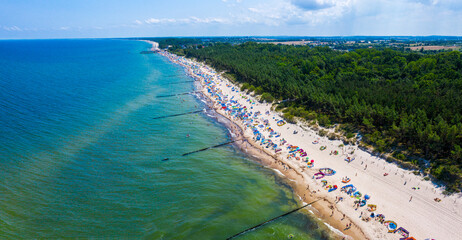 Wybrzeże morza bałtyckiego i piaszczysta plaża z opalającymi i kąpiącymi się plażowiczami w miejscowości Sarbinowo, widok z lotu ptaka - obrazy, fototapety, plakaty